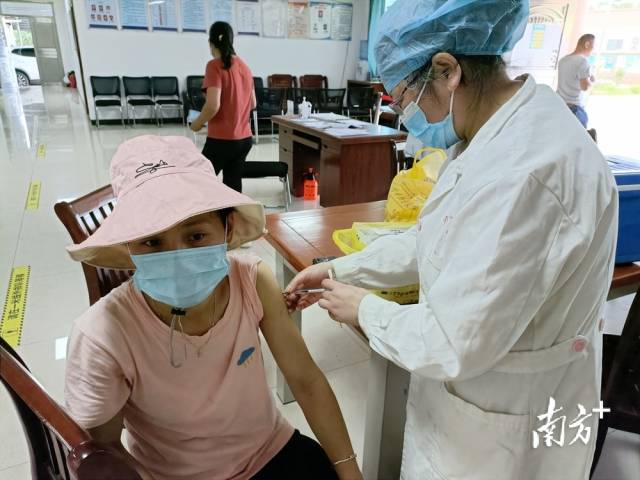 醫(yī)護(hù)人員為村民接種疫苗。