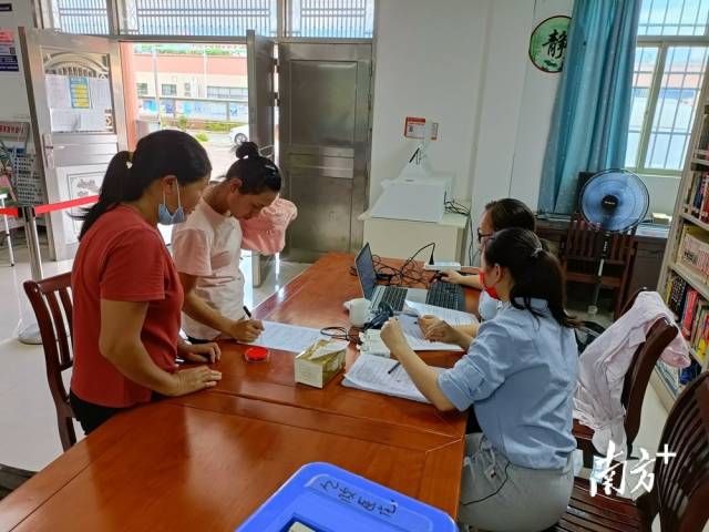 鎮(zhèn)、村干部為村民進(jìn)行接種信息錄入。