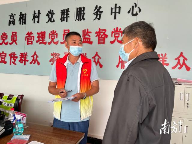 正在為群眾辦事的沈家江（左）。