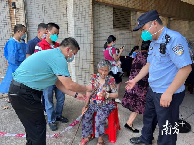 連州市委常委、副市長(zhǎng)、九陂鎮(zhèn)黨委書記綦鴻偉在核酸檢測(cè)現(xiàn)場(chǎng)協(xié)助老人參加核酸檢測(cè)，為老人做好防暑措施。