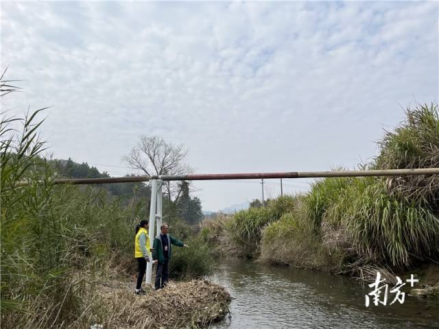 余榮華與戴海玲查看水渠建設(shè)情況。